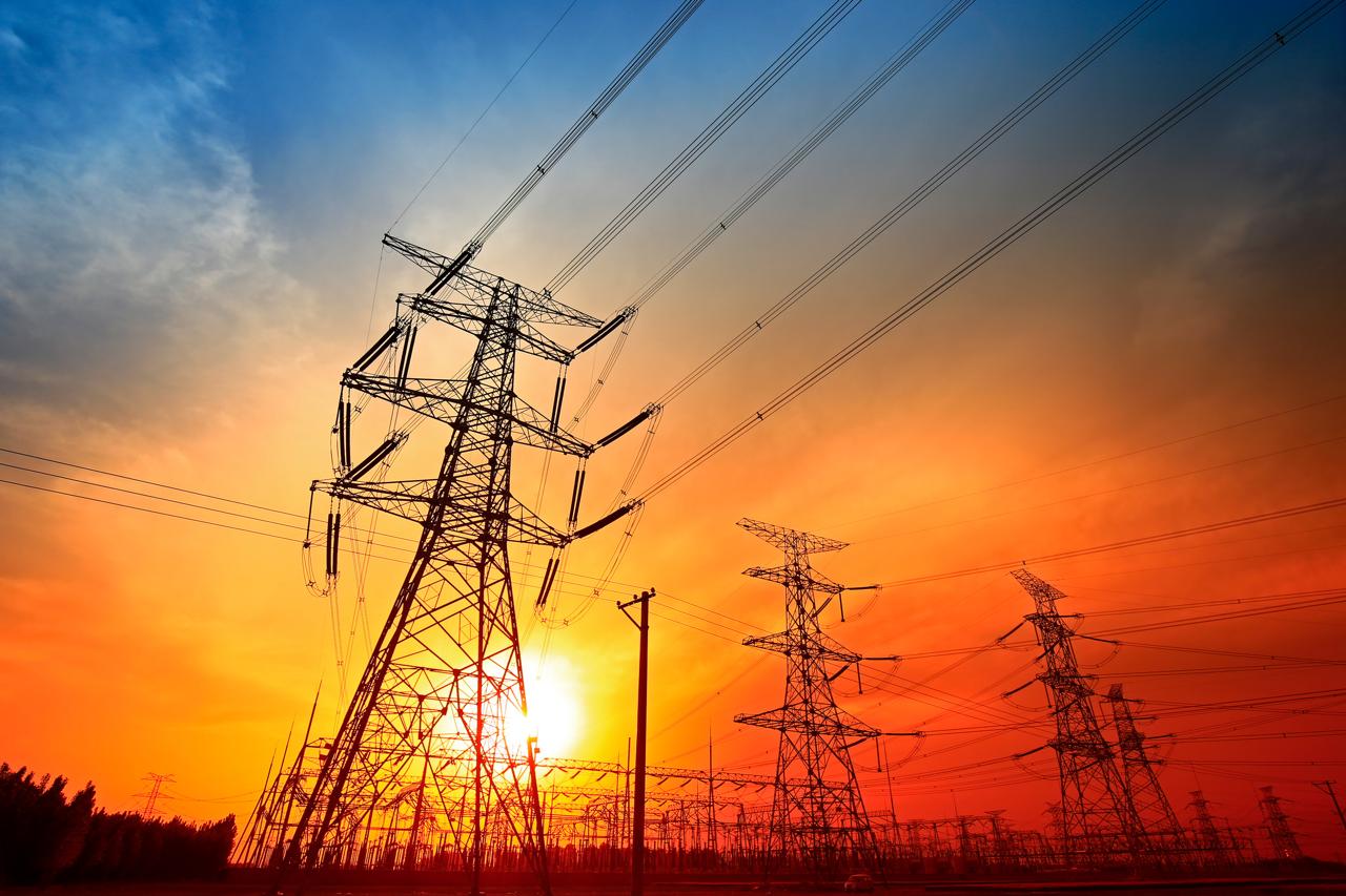 High-voltage power lines at sunset.